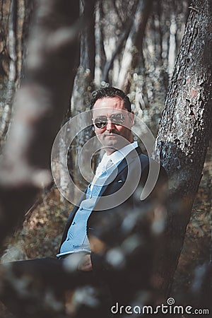 Stylish groom posing in the woods Stock Photo