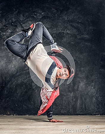 Stylish guy performs breakdance acrobatic elements. Stock Photo