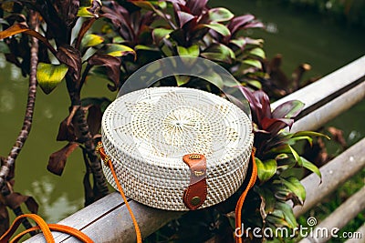 Stylish handmade rattan eco friendly handbag on a tropical background. Bali island. Stock Photo