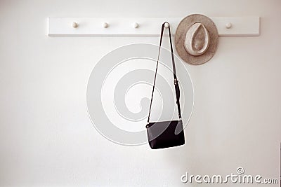 Hat and bag hanging on pegs Stock Photo