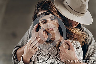 stylish hipster couple gently hugging. man in hat sensual touching boho woman in knitted sweater. atmospheric sensual moment. Stock Photo