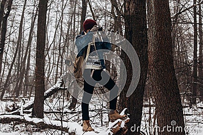 Stylish hipster traveler holding camera and making photo in snow Stock Photo