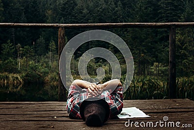 Stylish hipster traveler playing harmonica at sunny lake in the Stock Photo