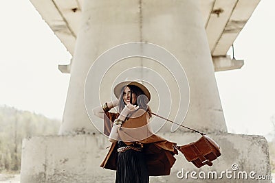 Stylish hipster woman having fun, in hat with windy hair near ri Stock Photo