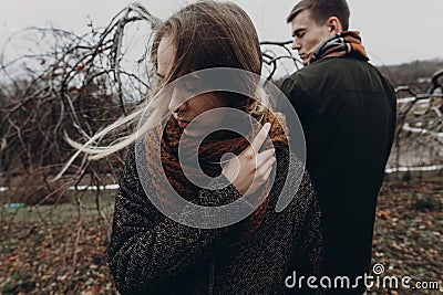 stylish hipster woman and man posing in windy autumn park. sensual atmospheric moment with space for text. fashionable cool Stock Photo