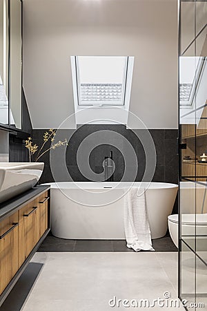Stylish interior of bathroom with bathtub, shower, towels and other personal bathroom accessories. Modern and design interior. Stock Photo