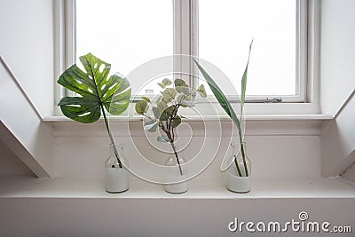 The stylish interior of home garden with different ceramic and concrete pots on the window sill. Stock Photo