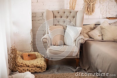 Stylish interior of room with comfortable grey armchair and pillows. Cozy decorated living room for Christmas. Rustic home design Stock Photo