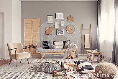 Stylish living room interior design with scandinavian settee, grey wall and natural accents Stock Photo