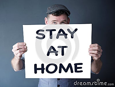Stylish man holding a sign with the words Stay At Home Stock Photo