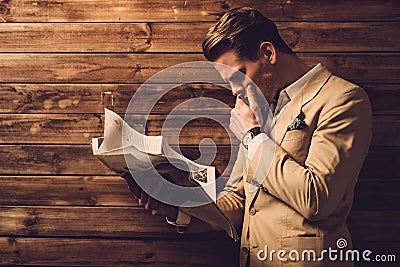 Stylish man with newspaper in rural cottage interior Stock Photo