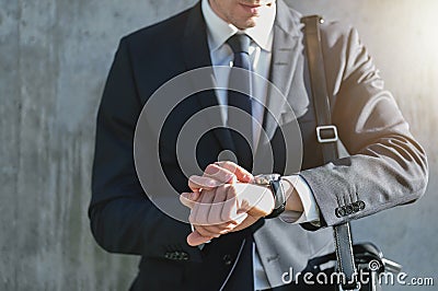 Stylish man wearing suit looks at watch Stock Photo