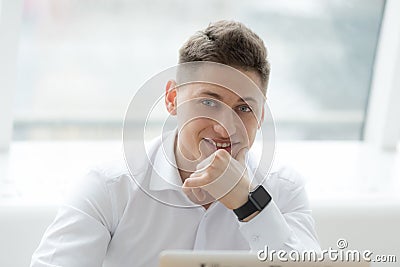Stylish middle-aged businessman looking at camera with toothy smile while working on project in cozy small cafe Stock Photo