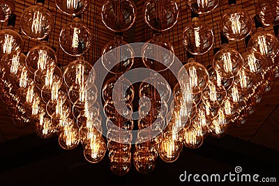Stylish, modern and decorative lamps of Edison of round shape in the rows. Light bulbs in retro style. A lot celling Stock Photo