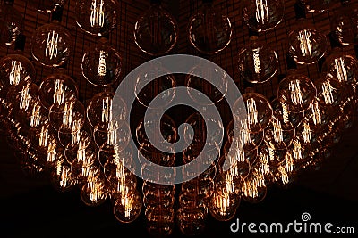 Stylish, modern and decorative lamps of Edison of round shape in the rows. Light bulbs in retro style. A lot celling Stock Photo