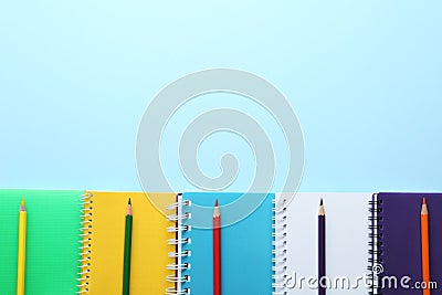 Stylish notebooks and pencils on blue background, flat lay. Space for text Stock Photo