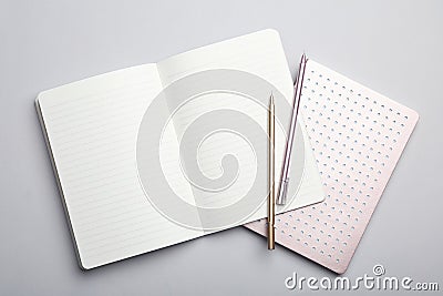 Stylish notebooks and pens on grey background Stock Photo