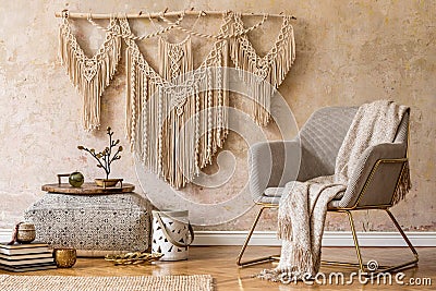 Stylish oriental living room with design armchair, beautiful macrame, carpet, decorations and elegant accessories. Stock Photo