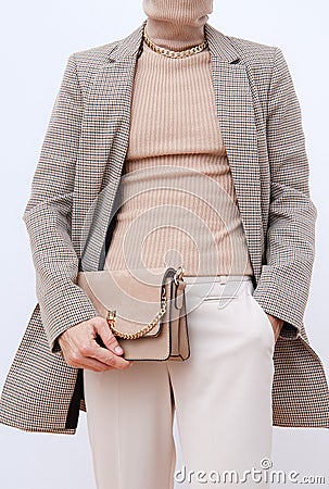 Stylish paris Lady. Details of everyday look. Casual beige checkered jacket and accessories bag and chain.Trendy Minimalistic Stock Photo