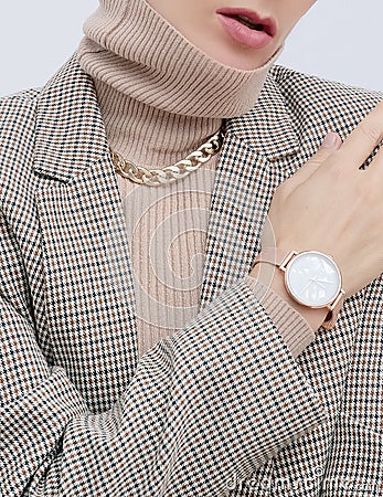 Stylish paris Lady. Details of everyday look. Casual beige checkered jacket and accessories watch and chain. Trendy Minimalistic Stock Photo