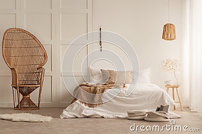 Stylish peacock chair in elegant bedroom, photo with copy space on the empty wall Stock Photo