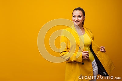 Stylish positive young woman on yellow background, copy space. Stock Photo