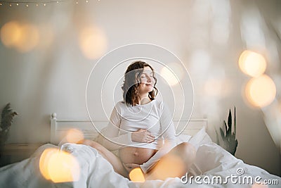 Stylish pregnant mom hugging belly with love and care, waiting for baby. Motherhood concept, magic time. Happy pregnant woman in Stock Photo