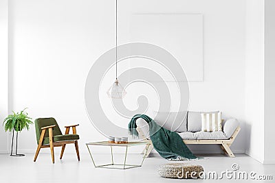 Retro armchair next to industrial coffee table with candles in trendy living room interior with scandinavian sofa and Stock Photo