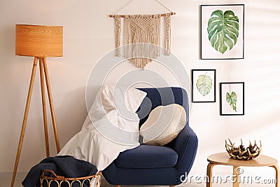 Stylish room interior with comfortable armchair, blankets and beautiful decor elements Stock Photo