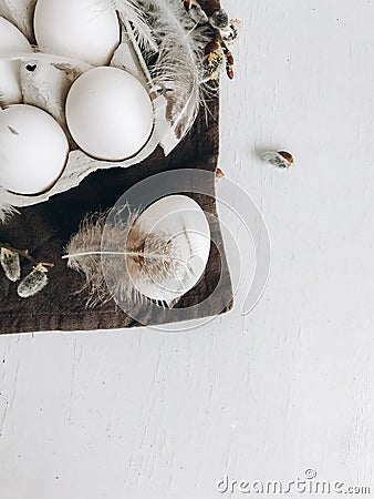 Stylish rural Easter flat lay. Natural easter eggs, feathers, pussy willow branches on rustic table Stock Photo