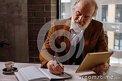Stylish senior businessman resting. drinking coffee while working Stock Photo