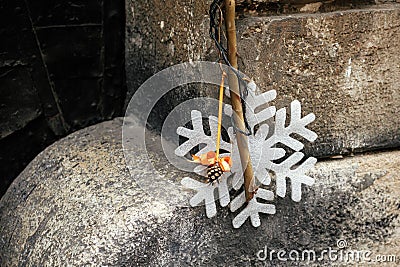 Stylish simple christmas decoration with branch, orange ornaments and snowflake on old building. Christmas festive street decor Stock Photo