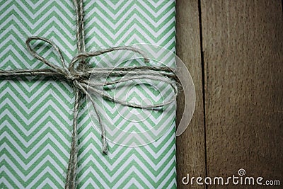 Stylish simple wrapped gift for holidays, with lines, on woode Stock Photo