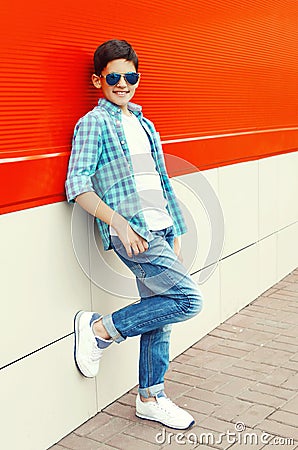 Stylish smiling child boy wearing sunglasses and shirt in city Stock Photo