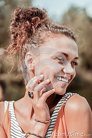 Stylish smiling young woman wearing nice ring and bracelets feeling happy Stock Photo