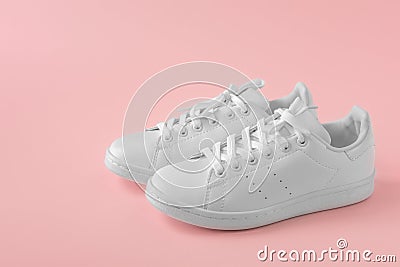 Stylish sneakers. Pair of new white sneakers on pink pastel background. New white leather sneakers sports shoes. Copyspace Stock Photo