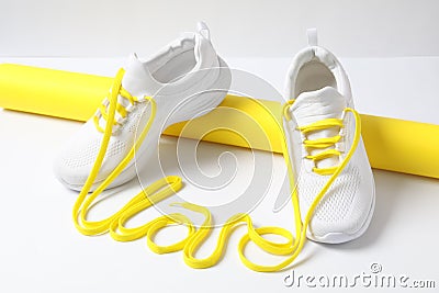 Stylish sneakers and word Love made with yellow shoe laces on white background Stock Photo