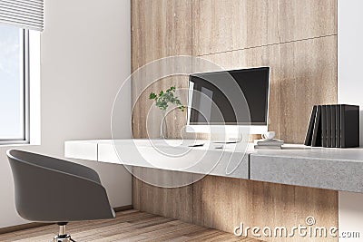 Stylish sunny work space with eco interior, modern computer on concrete console and green plane in glass vase Stock Photo