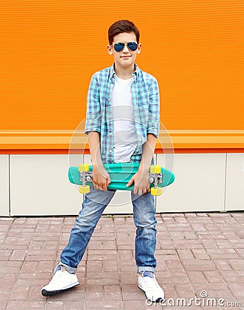 Stylish teenager boy wearing a shirt, sunglasses and skateboard Stock Photo