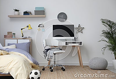 Stylish teenager`s room interior with bed and workplace Stock Photo