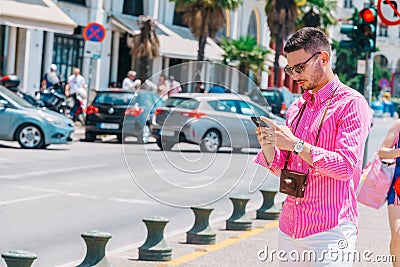 Stylish tourist calling a lift on his smartphone Stock Photo