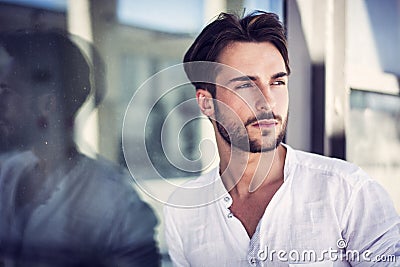 Stylish trendy young man standing outdoor against window Stock Photo