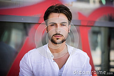 Stylish trendy young man standing outdoor against window Stock Photo