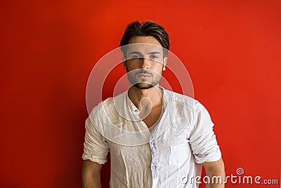 Stylish trendy young man standing outdoor red wall Stock Photo