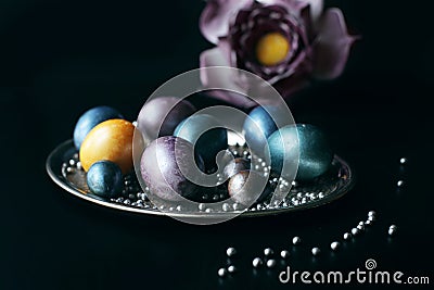 Stylish unusual eggs painted for Easter lie on a silver tray Stock Photo