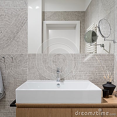 Stylish washbasin in bathroom with modern, patterned tiles, close-up Stock Photo