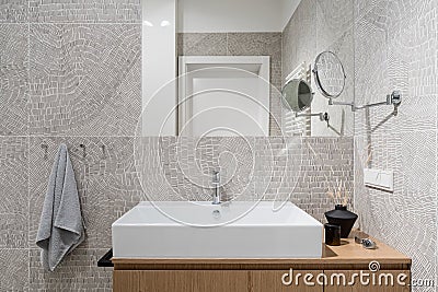Stylish washbasin in bathroom with modern, patterned tiles Stock Photo