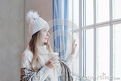 Stylish winter woman holding hot dring and resting at home, romantic portrait Stock Photo