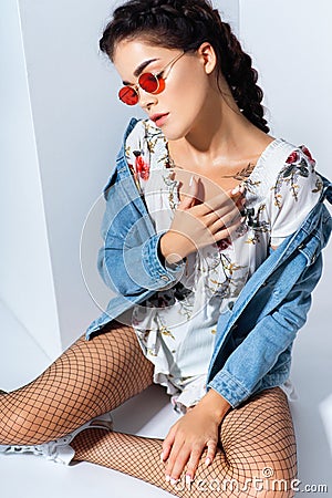 Stylish woman with braid in sunglasses and jacket with white ethnic embroidery Stock Photo