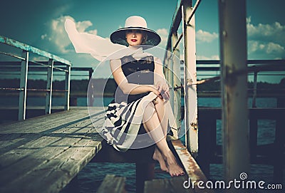 Stylish woman on old wooden pier Stock Photo